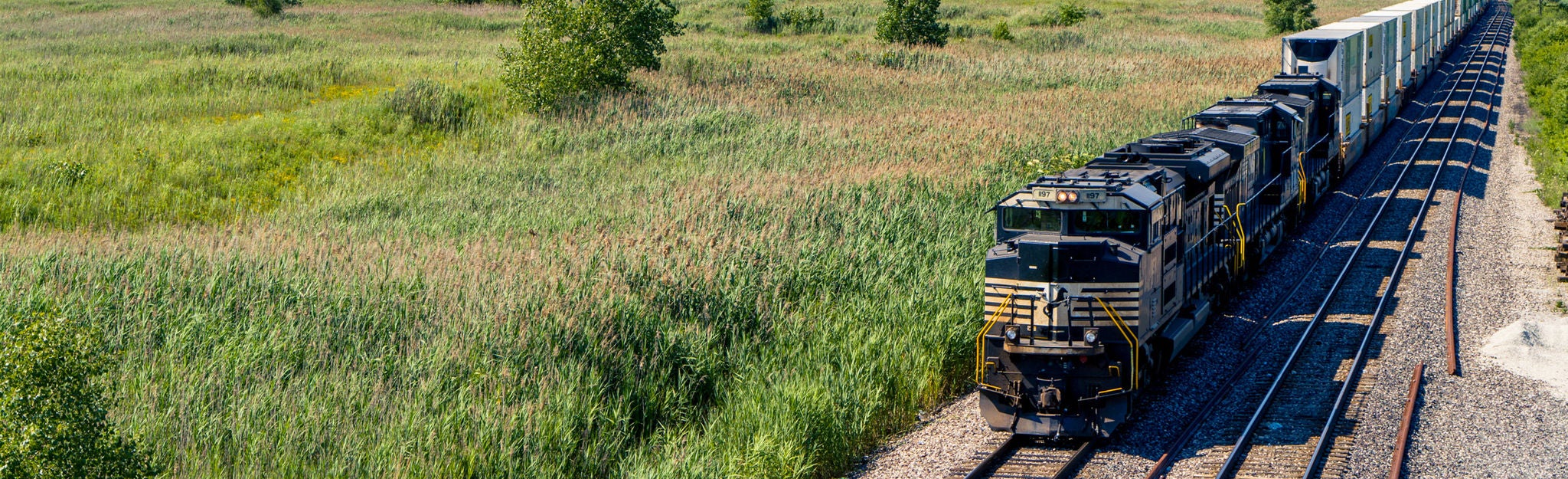 Train moving through farmland  